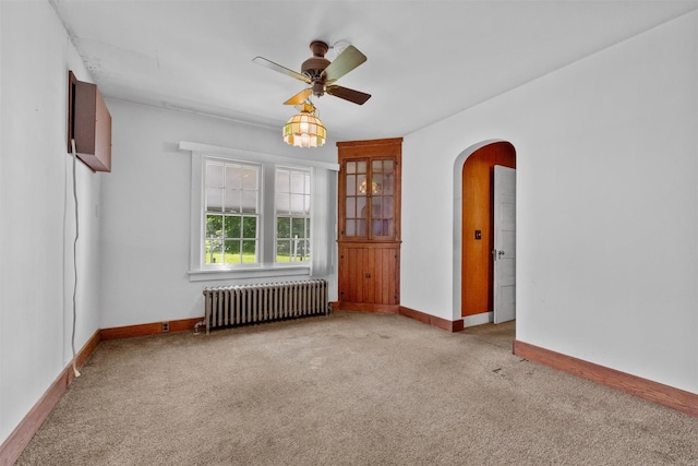 61 Spackenkill Rd, Poughkeepsie, NY 12603 - empty room with radiator heating unit, arched walkways, light colored carpet, ceiling fan, and baseboards