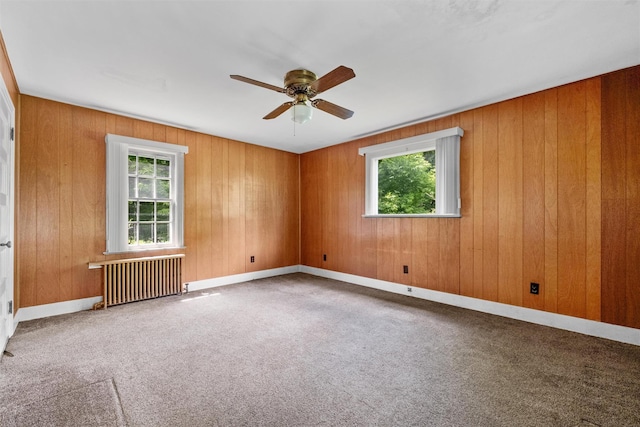 61 Spackenkill Rd, Poughkeepsie, NY 12603 - unfurnished room with radiator heating unit, healthy amount of natural light, a ceiling fan, carpet flooring, and wooden walls