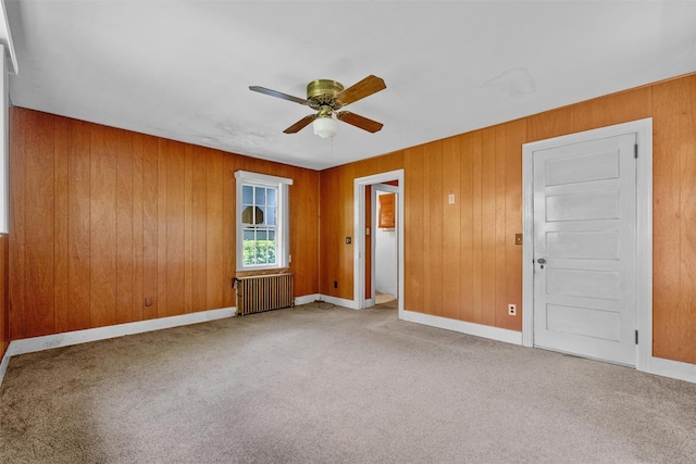 61 Spackenkill Rd, Poughkeepsie, NY 12603 - carpeted spare room with radiator heating unit, a ceiling fan, and wood walls