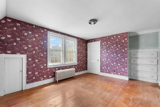 61 Spackenkill Rd, Poughkeepsie, NY 12603 - unfurnished bedroom featuring radiator, wood-type flooring, wallpapered walls, and lofted ceiling