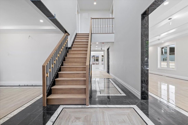 19 Maple Ave, Cedarhurst, NY 11516 - staircase featuring inlaid floor details, baseboards, recessed lighting, marble tiled flooring, and a high ceiling