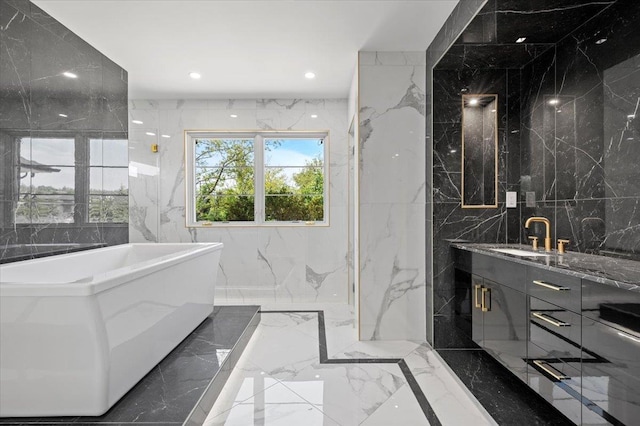19 Maple Ave, Cedarhurst, NY 11516 - full bathroom featuring marble tiled floors, tile walls, a freestanding bath, vanity, and stone wall