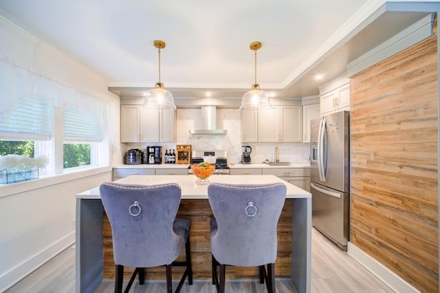 322 Noxon Rd, Poughkeepsie, NY 12603 - kitchen featuring stainless steel fridge with ice dispenser, wall chimney exhaust hood, range with gas cooktop, a kitchen island, and light countertops