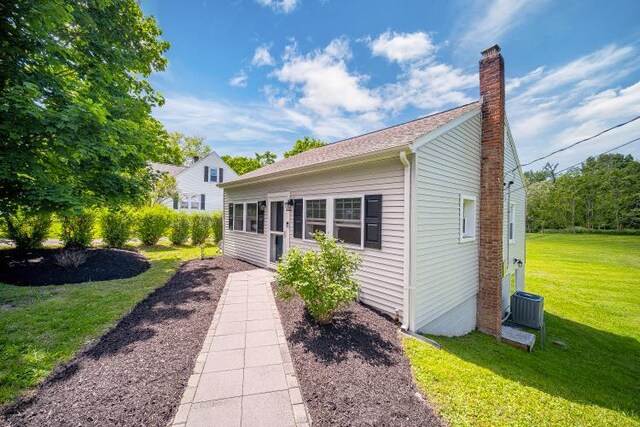 322 Noxon Rd, Poughkeepsie, NY 12603 - view of front facade featuring a chimney, a front lawn, and central AC