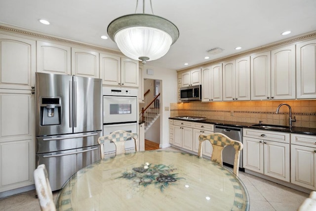 5 Coventry Rd, Syosset, NY 11791 - kitchen with appliances with stainless steel finishes, a sink, decorative backsplash, recessed lighting, and dark stone counters