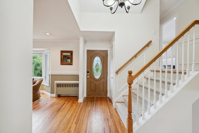 5 Coventry Rd, Syosset, NY 11791 - foyer with radiator heating unit, a chandelier, wood finished floors, stairway, and ornamental molding