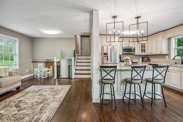 12 Pleasant Pl, Farmingville, NY 11738 - kitchen featuring stainless steel appliances, a breakfast bar, light stone counters, dark wood-type flooring, and glass insert cabinets