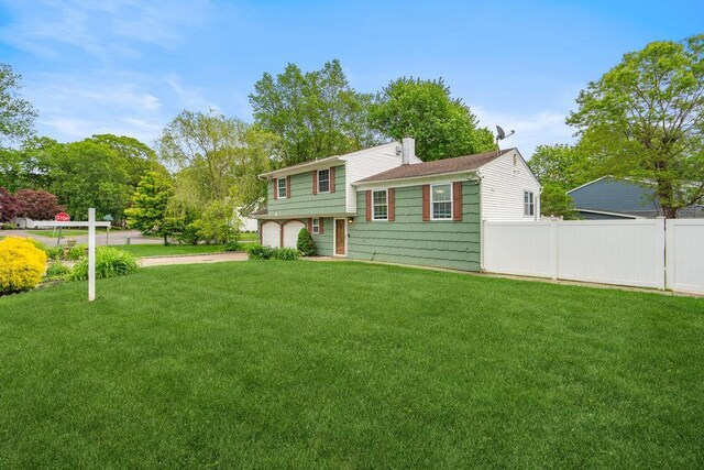 12 Pleasant Pl, Farmingville, NY 11738 - tri-level home featuring an attached garage, a chimney, and driveway