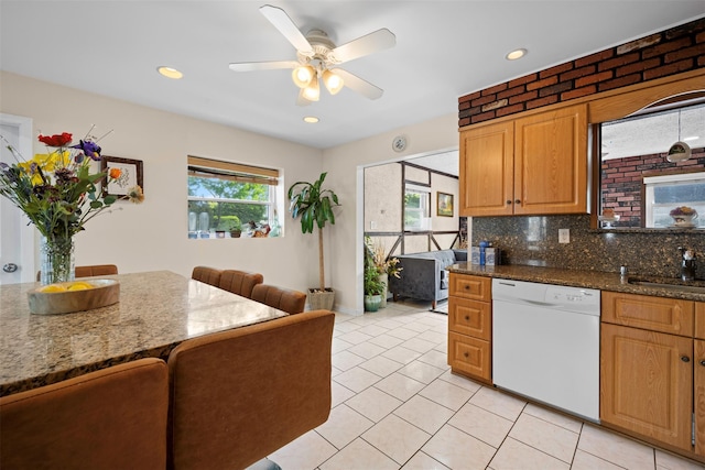 21 Westgate Rd, Massapequa Park, NY 11762 - kitchen with white dishwasher, light tile patterned floors, ceiling fan, tasteful backsplash, and dark stone counters