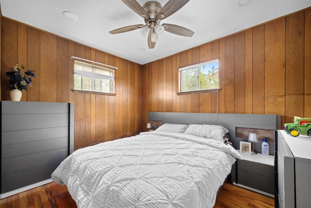 21 Westgate Rd, Massapequa Park, NY 11762 - bedroom with multiple windows, wood walls, wood finished floors, and ceiling fan