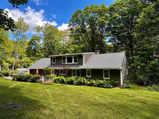 287 Hunns Lake Rd, Stanfordville, NY 12581 - view of front of house featuring a chimney, a front lawn, roof with shingles, and view of wooded area