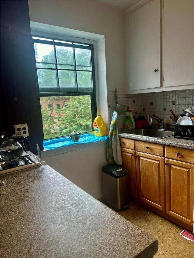 147-11 79th Ave Unit 3L, Flushing, NY 11367 - kitchen featuring a sink, brown cabinets, and tasteful backsplash