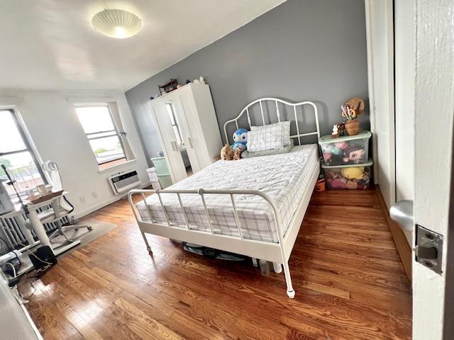 215-19 48th Ave Unit 3C, Bayside, NY 11364 - bedroom with an AC wall unit and wood finished floors