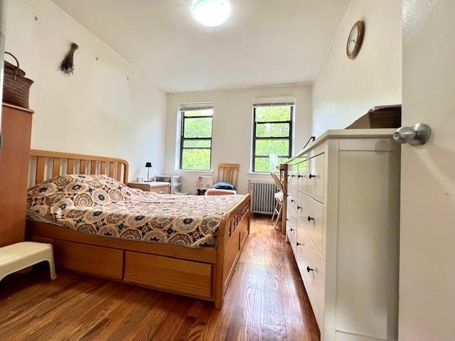 215-19 48th Ave Unit 3C, Bayside, NY 11364 - bedroom featuring radiator heating unit and wood finished floors
