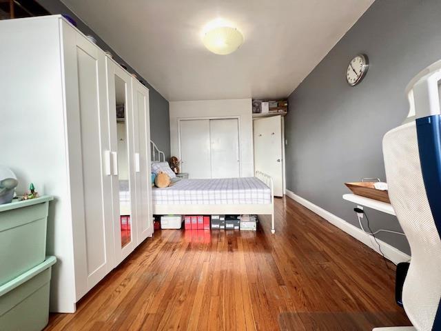 215-19 48th Ave Unit 3C, Bayside, NY 11364 - bedroom featuring wood finished floors, a closet, and baseboards