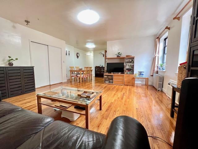 215-19 48th Ave Unit 3C, Bayside, NY 11364 - living room with radiator heating unit and wood finished floors