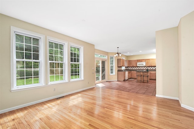 36 Bellefair Rd, Rye Brook, NY 10573 - unfurnished living room featuring a chandelier and light wood-style floors
