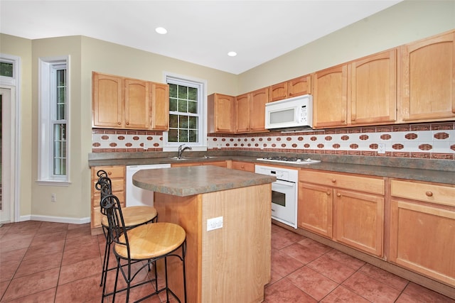 36 Bellefair Rd, Rye Brook, NY 10573 - kitchen featuring a breakfast bar, white appliances, light brown cabinetry, light tile patterned floors, and recessed lighting