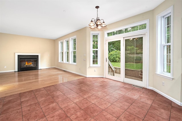 36 Bellefair Rd, Rye Brook, NY 10573 - unfurnished living room featuring healthy amount of natural light, a chandelier, a fireplace with flush hearth, and light tile patterned flooring