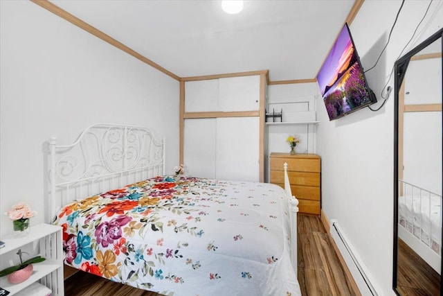 735 E 216th St, Bronx, NY 10467 - bedroom with a baseboard heating unit, wood finished floors, and a closet