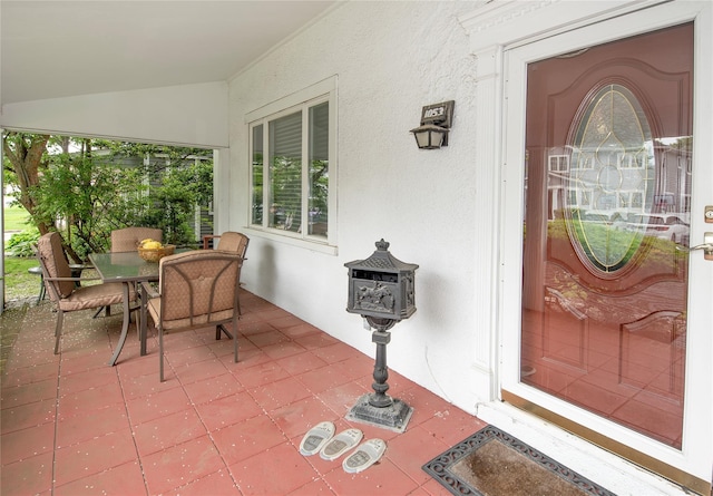 1053 Quentin Pl, Woodmere, NY 11598 - view of exterior entry featuring stucco siding, outdoor dining space, and a patio