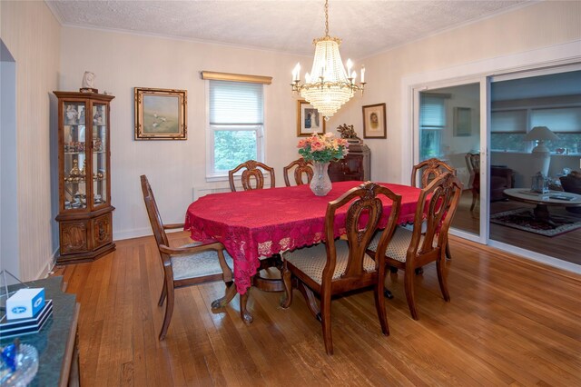 1053 Quentin Pl, Woodmere, NY 11598 - dining room with a chandelier, wood finished floors, ornamental molding, and a textured ceiling