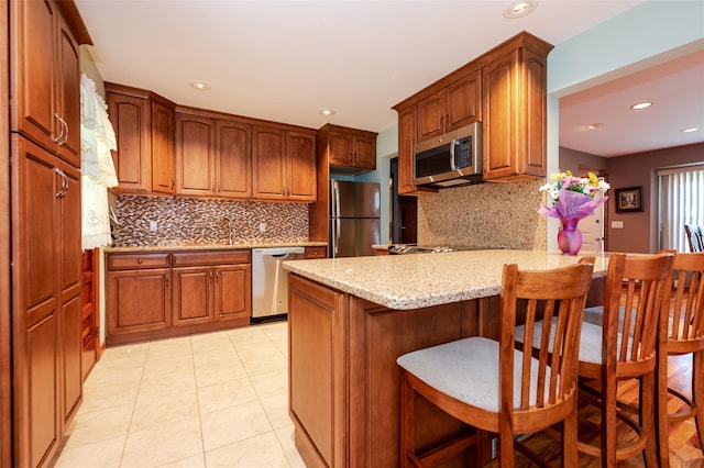 1158 Lorraine Dr, Franklin Square, NY 11010 - kitchen featuring stainless steel appliances, a peninsula, light stone countertops, recessed lighting, and tasteful backsplash