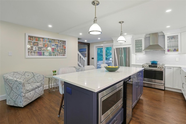 1 Lakeview Rd, South Salem, NY 10590 - kitchen with wall chimney range hood, stainless steel appliances, a breakfast bar area, white cabinets, and glass insert cabinets