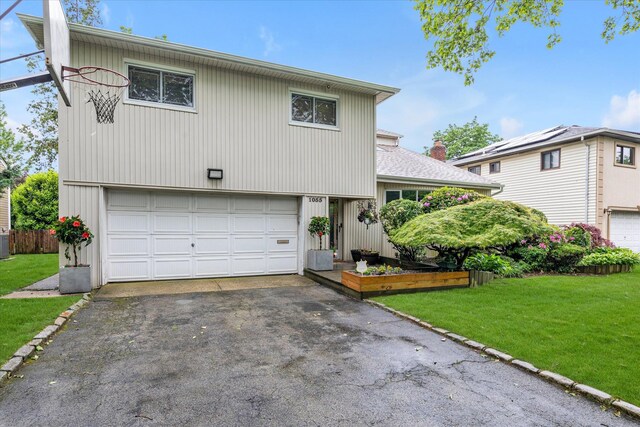 1055 Cedarhurst St, North Woodmere, NY 11581 - view of front of house featuring driveway, a front lawn, an attached garage, and cooling unit