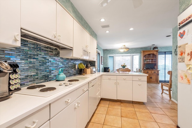 1055 Cedarhurst St, North Woodmere, NY 11581 - kitchen featuring backsplash, light countertops, white appliances, white cabinets, and light tile patterned floors