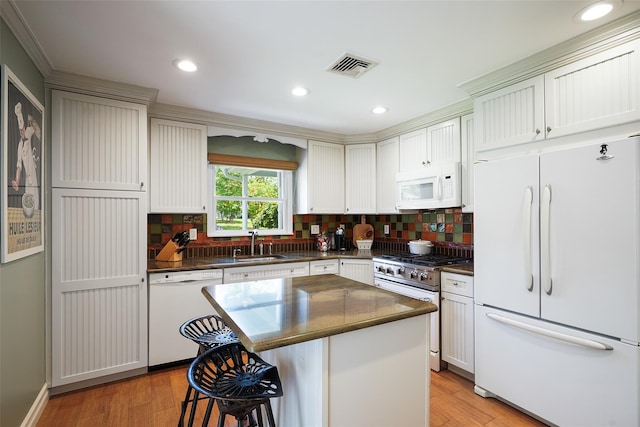 801 Syska Rd, Ossining, NY 10562 - kitchen with white appliances, a sink, dark countertops, backsplash, and a kitchen breakfast bar