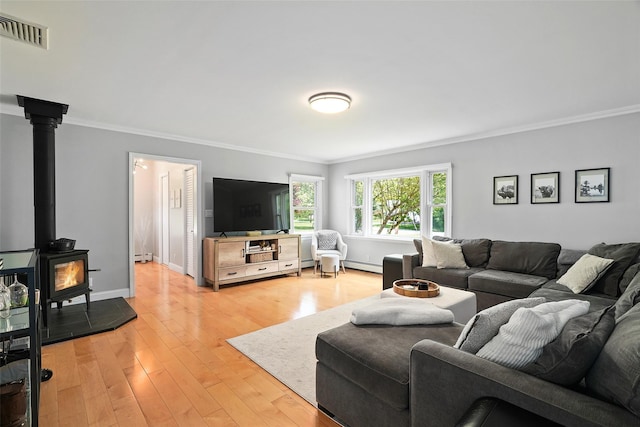 801 Syska Rd, Ossining, NY 10562 - living room featuring ornamental molding, a baseboard heating unit, light wood-type flooring, a wood stove, and baseboards