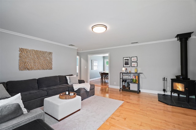 801 Syska Rd, Ossining, NY 10562 - living area with light wood finished floors, a wood stove, ornamental molding, and baseboards