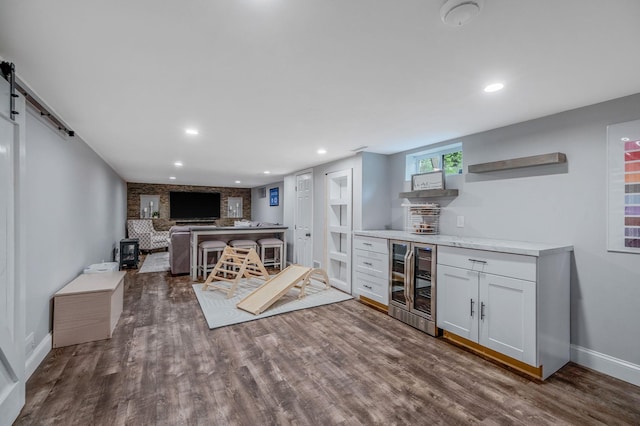 8 Bridle Path Rd, Smithtown, NY 11787 - indoor dry bar with wine cooler, dark wood finished floors, baseboards, a barn door, and recessed lighting