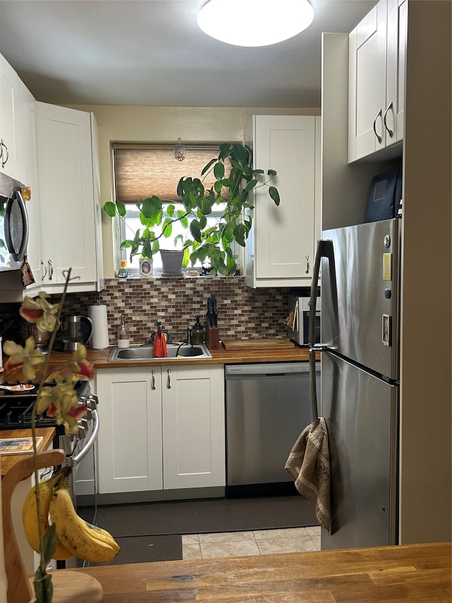 110-20 71st Ave Unit 411, Forest Hills, NY 11375 - kitchen featuring stainless steel appliances, a sink, white cabinetry, and backsplash