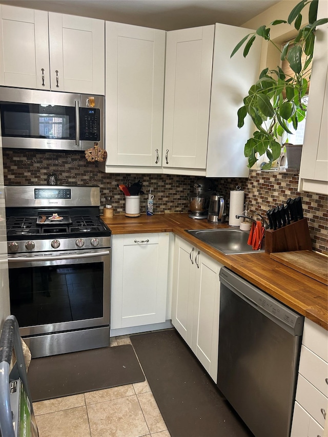 110-20 71st Ave Unit 411, Forest Hills, NY 11375 - kitchen featuring wooden counters, appliances with stainless steel finishes, a sink, tasteful backsplash, and white cabinetry