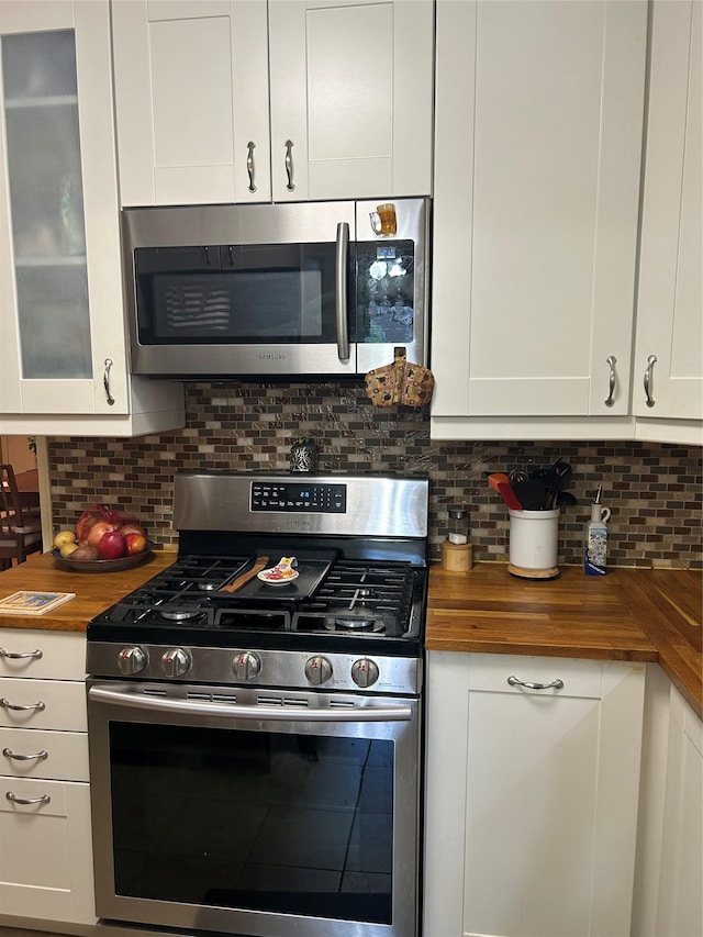 110-20 71st Ave Unit 411, Forest Hills, NY 11375 - kitchen featuring butcher block countertops, appliances with stainless steel finishes, white cabinets, and decorative backsplash