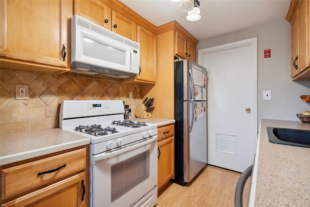 65 Sagamore Hills Dr, Port Jefferson Station, NY 11776 - kitchen with white appliances, light wood-style flooring, light countertops, and decorative backsplash