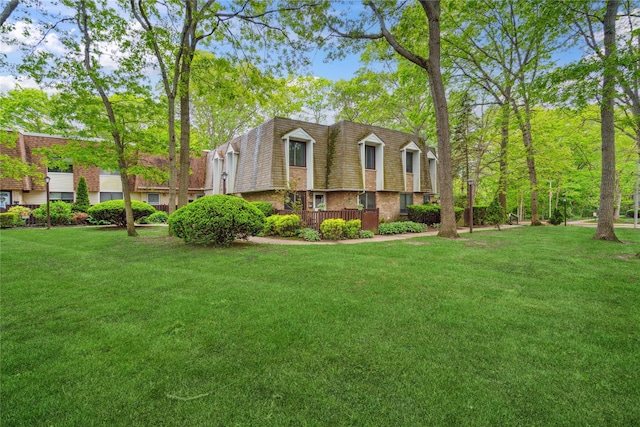 65 Sagamore Hills Dr, Port Jefferson Station, NY 11776 - view of front of property featuring mansard roof, a front yard, and brick siding