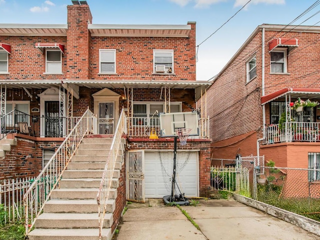 3333 Tiemann Ave, Bronx, NY 10469 - view of property featuring a garage, brick siding, concrete driveway, a chimney, and stairway
