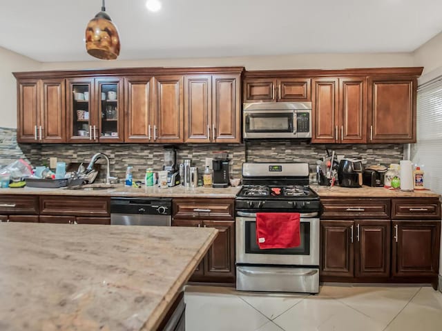 3333 Tiemann Ave, Bronx, NY 10469 - kitchen with stainless steel appliances, light stone countertops, tasteful backsplash, and glass insert cabinets