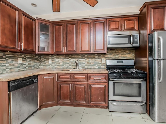 3333 Tiemann Ave, Bronx, NY 10469 - kitchen featuring stainless steel appliances, light tile patterned floors, a sink, and tasteful backsplash