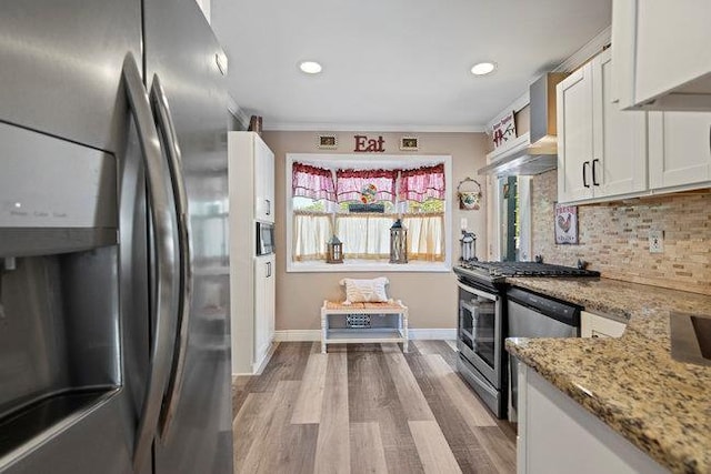 105 Fountain Ave, Selden, NY 11784 - kitchen with stainless steel appliances, white cabinetry, decorative backsplash, light stone counters, and baseboards