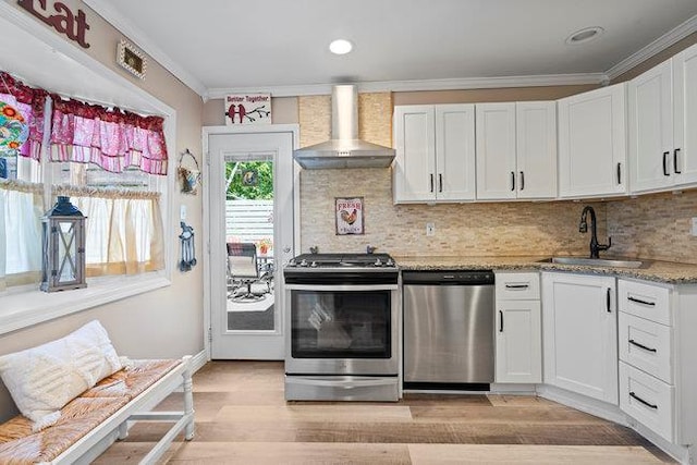 105 Fountain Ave, Selden, NY 11784 - kitchen with appliances with stainless steel finishes, wall chimney exhaust hood, a sink, light wood-type flooring, and ornamental molding