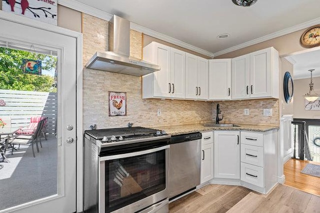 105 Fountain Ave, Selden, NY 11784 - kitchen with wall chimney range hood, stainless steel appliances, a sink, crown molding, and white cabinets