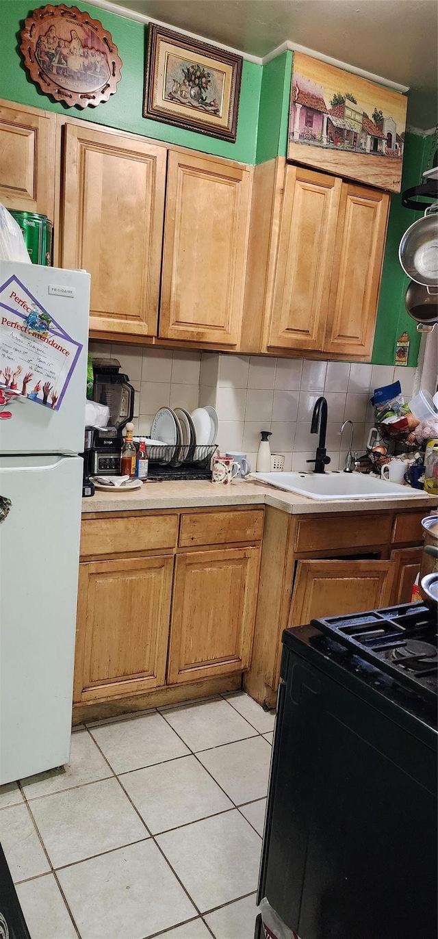 7 Metropolitan Oval Unit 5G, Bronx, NY 10462 - kitchen with freestanding refrigerator, black range with gas stovetop, light countertops, and a sink