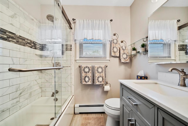 9 Duke St, North Babylon, NY 11703 - full bathroom featuring a baseboard heating unit, vanity, enclosed tub / shower combo, toilet, and wood finished floors