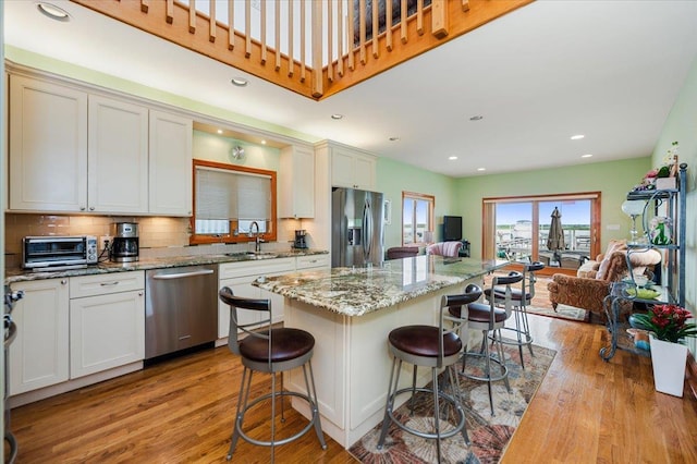 991 W Park Ave, Long Beach, NY 11561 - kitchen featuring stainless steel appliances, a sink, light wood-style floors, a breakfast bar, and open floor plan