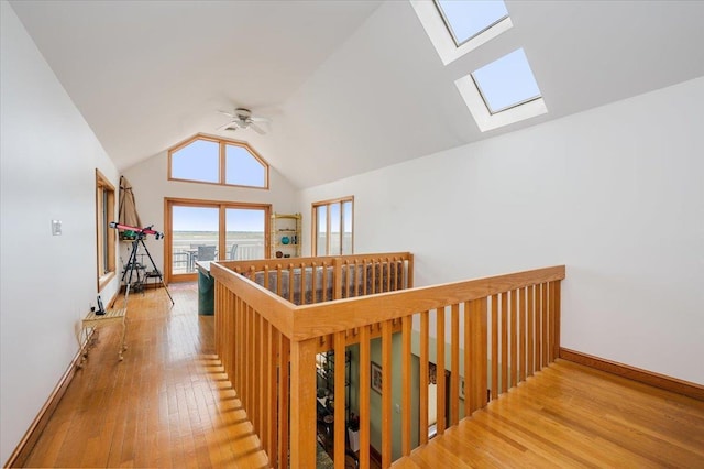 991 W Park Ave, Long Beach, NY 11561 - hallway with a skylight, wood finished floors, vaulted ceiling, an upstairs landing, and baseboards