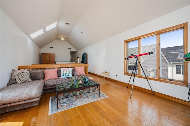 991 W Park Ave, Long Beach, NY 11561 - living area with a skylight, lofted ceiling, hardwood / wood-style floors, and baseboards
